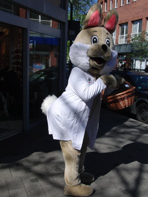 Oster-Maskottchen im Apotheker-Kittel mit Korb